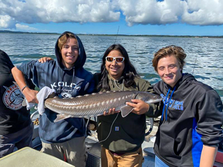 Group of Friends Pose with Their White Sturgeon